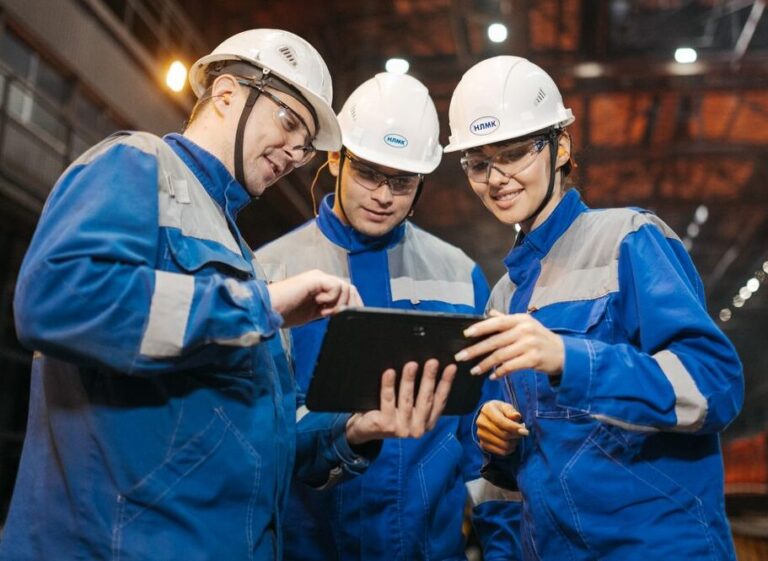 Equipe de techniciens terrain qui interagissent sur une tablette. Données partagées entre le bureau et les équipes terrain.